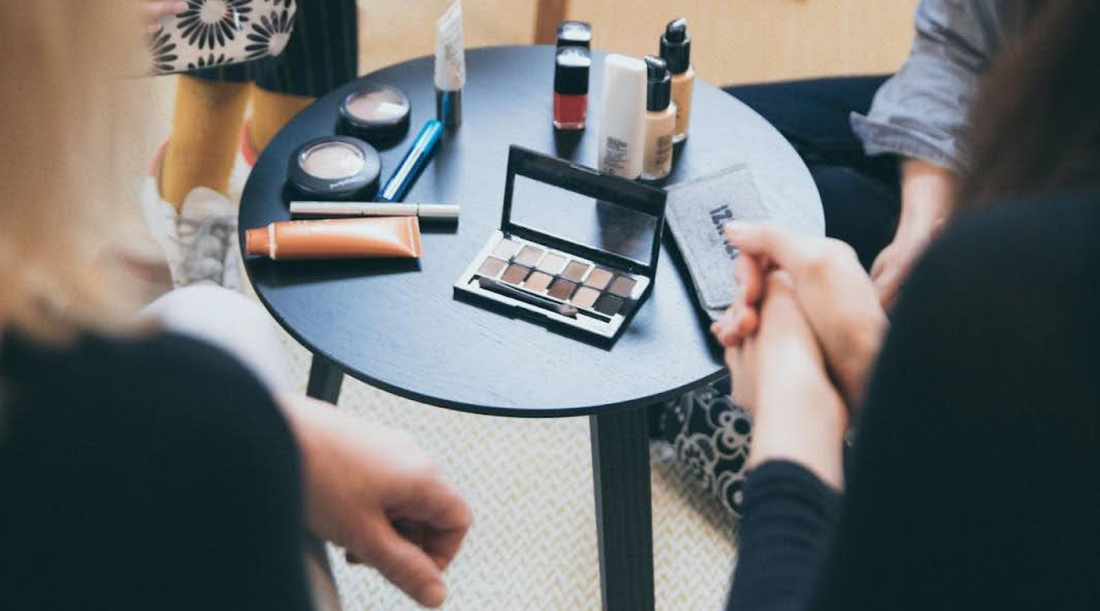 Women Sitting at Table with Makeup