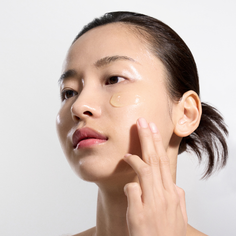 Woman applying cream to her face with a white background Woman applying cream to her face with a white background
