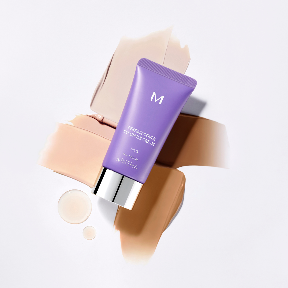A tube of Missha Perfect Cover Serum B.B. Cream with swatches of different shades and two drops of serum on a white background. A tube of Missha Perfect Cover Serum B.B. Cream with swatches of different shades and two drops of serum on a white background.