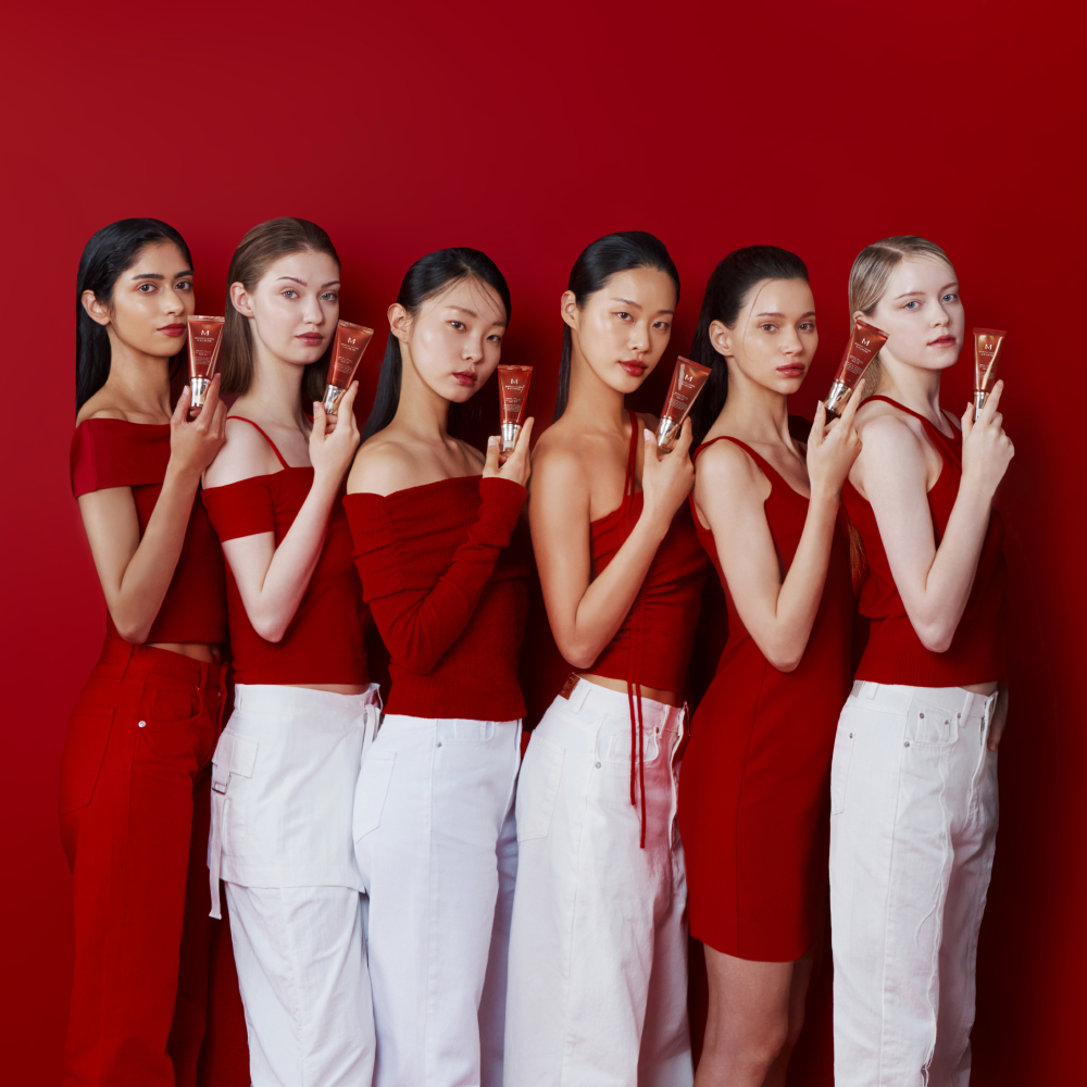 MISSHA Perfect Cover BB Cream campaign featuring diverse models in red outfits holding BB Cream tubes against a red background, highlighting flawless and radiant skin coverage MISSHA Perfect Cover BB Cream campaign featuring diverse models in red outfits holding BB Cream tubes against a red background, highlighting flawless and radiant skin coverage