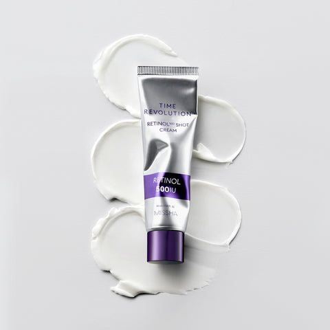 MISSHA Time Revolution Retinol 500 Shot Cream tube placed flat on a white surface with smooth cream swatches beneath it, showcasing its silky texture and elegant silver-purple packaging. MISSHA Time Revolution Retinol 500 Shot Cream tube placed flat on a white surface with smooth cream swatches beneath it, showcasing its silky texture and elegant silver-purple packaging.