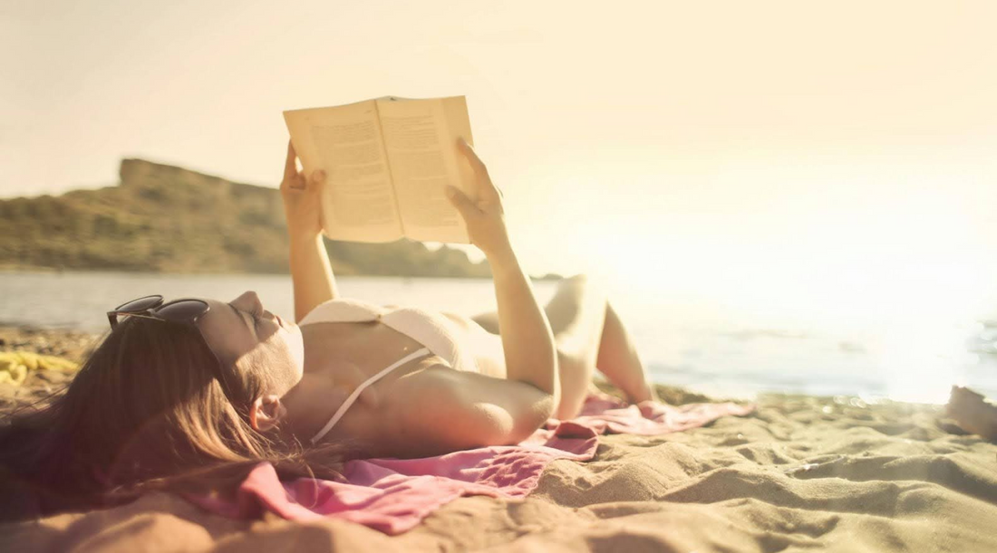 Woman Reading a Book on the Beach