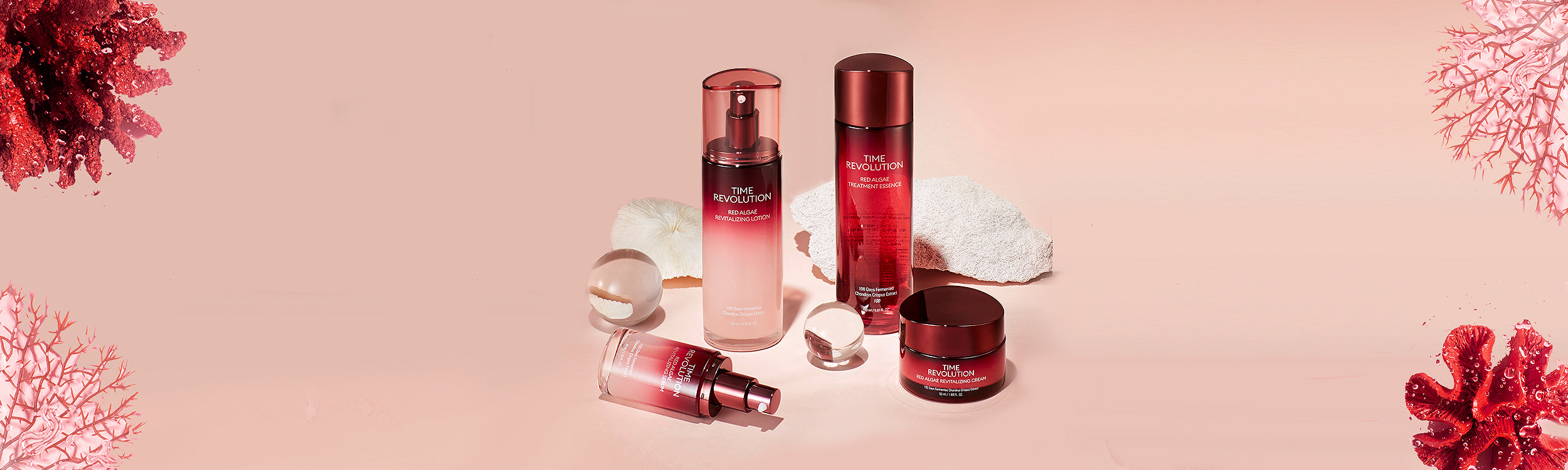Four Time Revolution skincare products with red algae, artfully arranged on a soft pink background with coral accents.