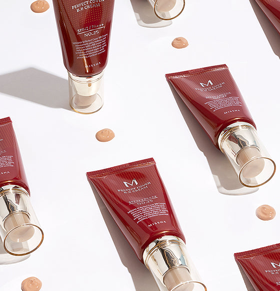 Multiple tubes of Missha Perfect Cover BB Cream arranged neatly with beige product swatches on a white background.