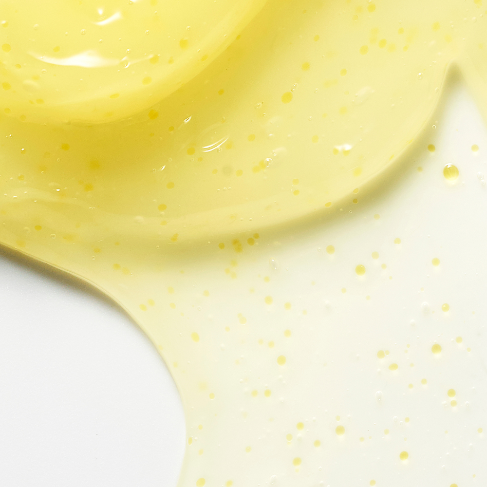 Close-up of a yellow gel with speckled pattern on a white background