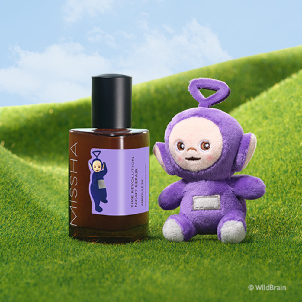 MISSHA Time Revolution Night Repair Ampoule featuring a Teletubbies character on the label, displayed on green grass beside a matching purple Teletubbies plush toy under a blue sky.