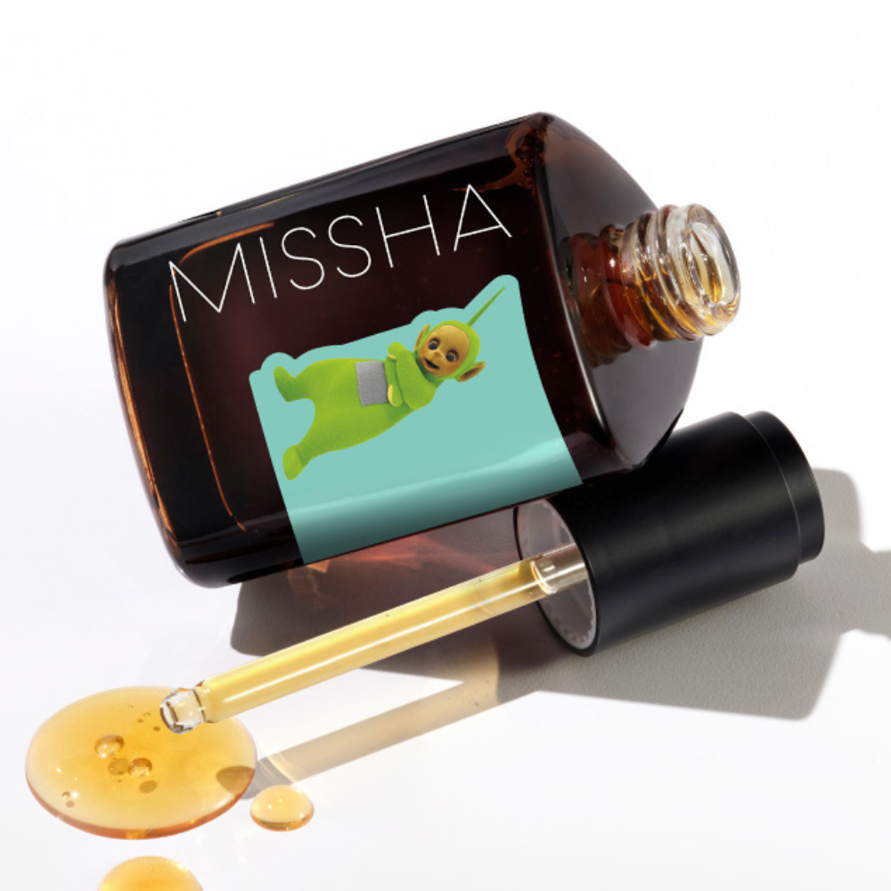 MISSHA Artemisia Calming Ampoule bottle lying on its side with a dropper and spilled golden serum, featuring a Teletubbies character on the mint green label.