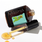 MISSHA Artemisia Calming Ampoule bottle lying on its side with a dropper and spilled golden serum, featuring a Teletubbies character on the mint green label.