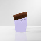 A MISSHA layering fit brush with brown bristles, partially inserted into a light purple holder with the brand name visible.