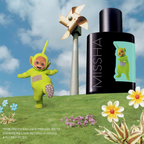 MISSHA Teletubbies edition skincare ampoule bottle featuring the green Teletubby on the label, displayed on a grassy hill with flowers, a windmill, and the Teletubby character posing beside it under a blue sky.