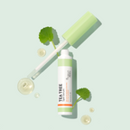 Tea tree spot serum with dropper and leaves on a light green background