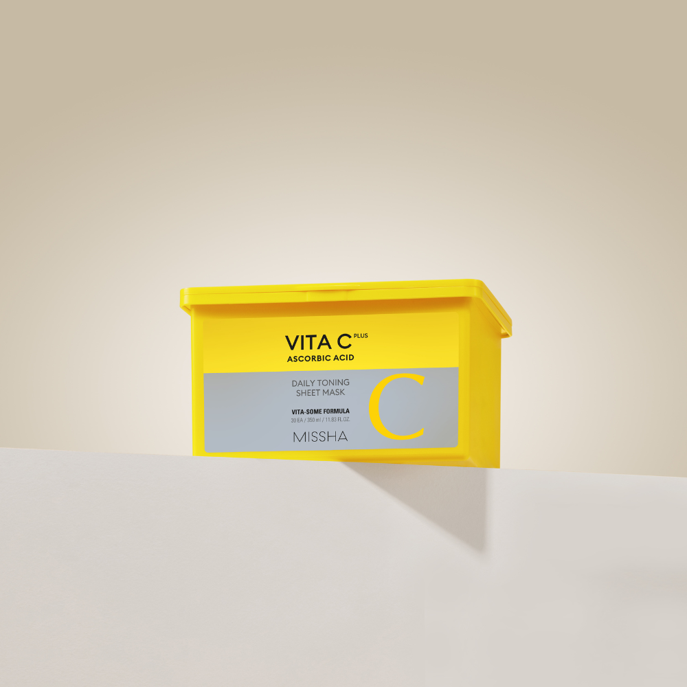 Yellow box of Missha Vita C sheet mask on a beige background