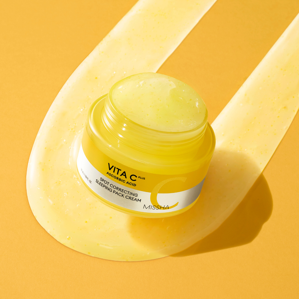 Yellow jar of skincare cream with a white label on a yellow background