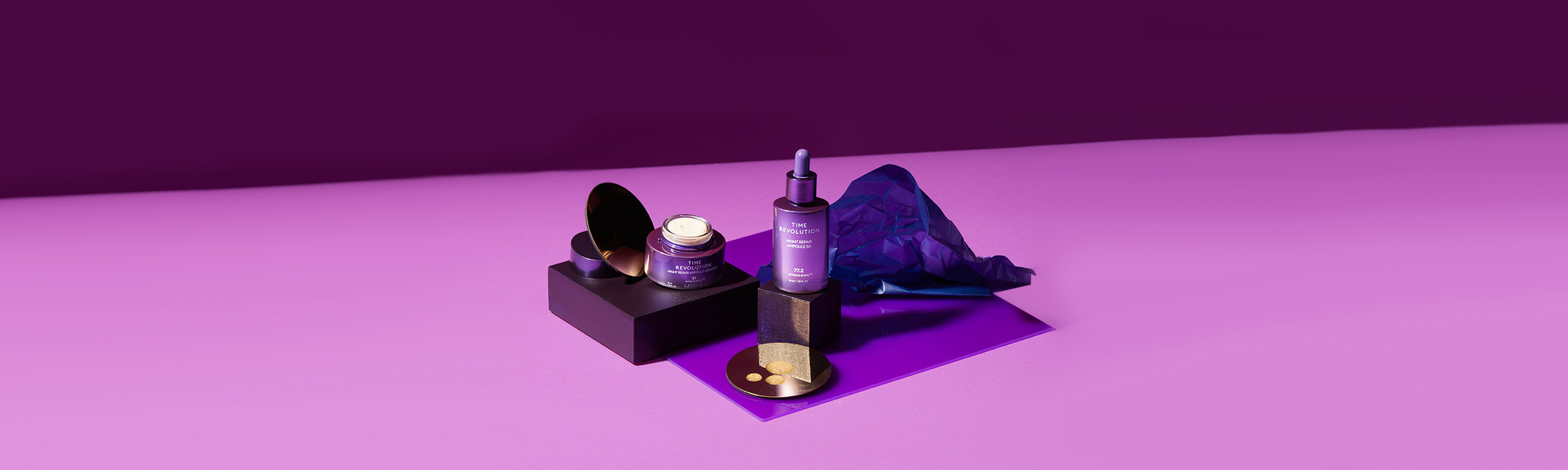 Two purple skincare products a cream jar and serum bottle elegantly displayed against a bold purple backdrop.