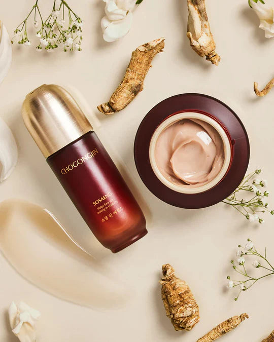 A luxury skincare set featuring Chogongjin serum and cream surrounded by herbal ingredients and delicate white flowers