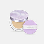 An open Missha Glow Cushion compact with a shimmery lilac lid, sitting next to the purple, flat, tear-drop shaped Missha Layering Puff. This image highlights the Korean beauty cushion foundation and the ergonomic design of the Missha makeup applicator puff.