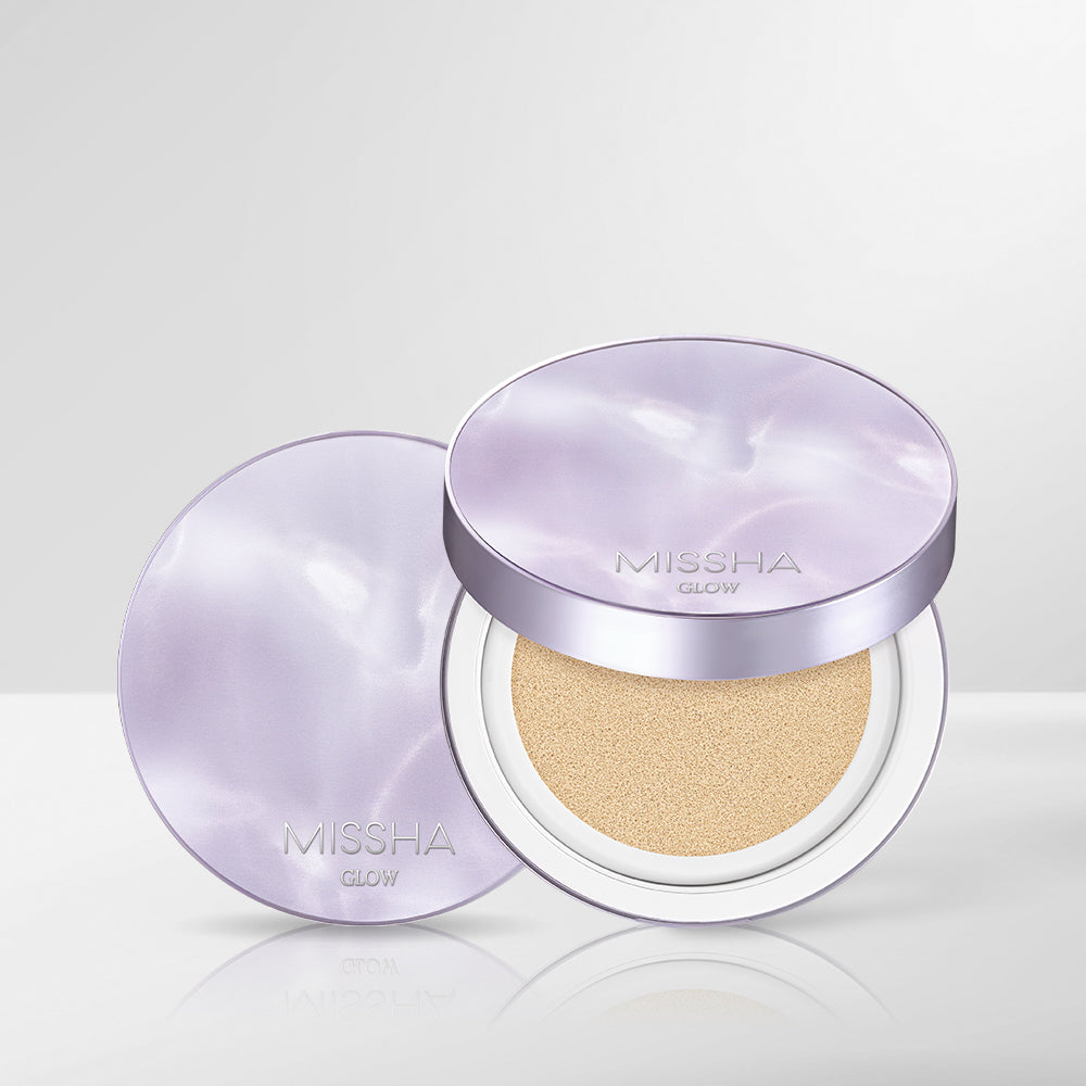 A compact BB cushion by MISSHA, with its lid open revealing the cushion inside. The product is presented in a sleek, round container with a purple and white color scheme.
