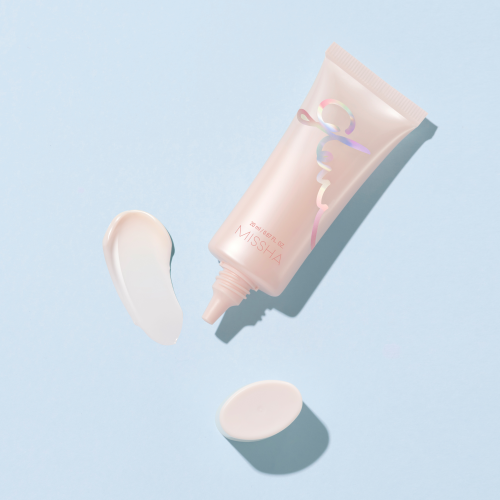 A closed container of Missha Glow Skin Balm with a pink and silver color scheme.