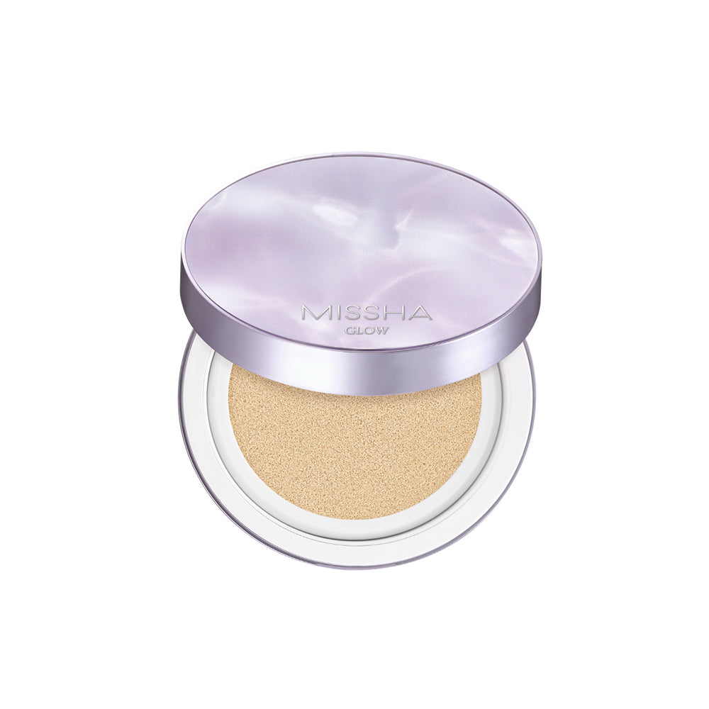 A compact Glow Layering Fit Cushion by Missha, with its lid open showing the BB cream inside. The cushion is pressed with a light-colored foundation, and the product is contained within a round, silver-colored case.