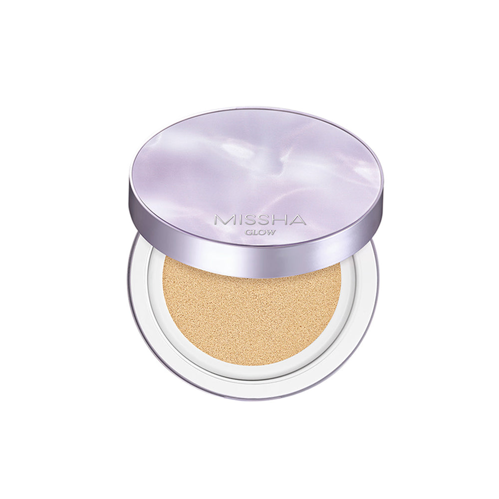 A compact Glow Layering Fit Cushion by Missha, with its lid open showing the BB cream inside. The cushion is pressed with a light-colored foundation, and the product is contained within a round, silver-colored case.