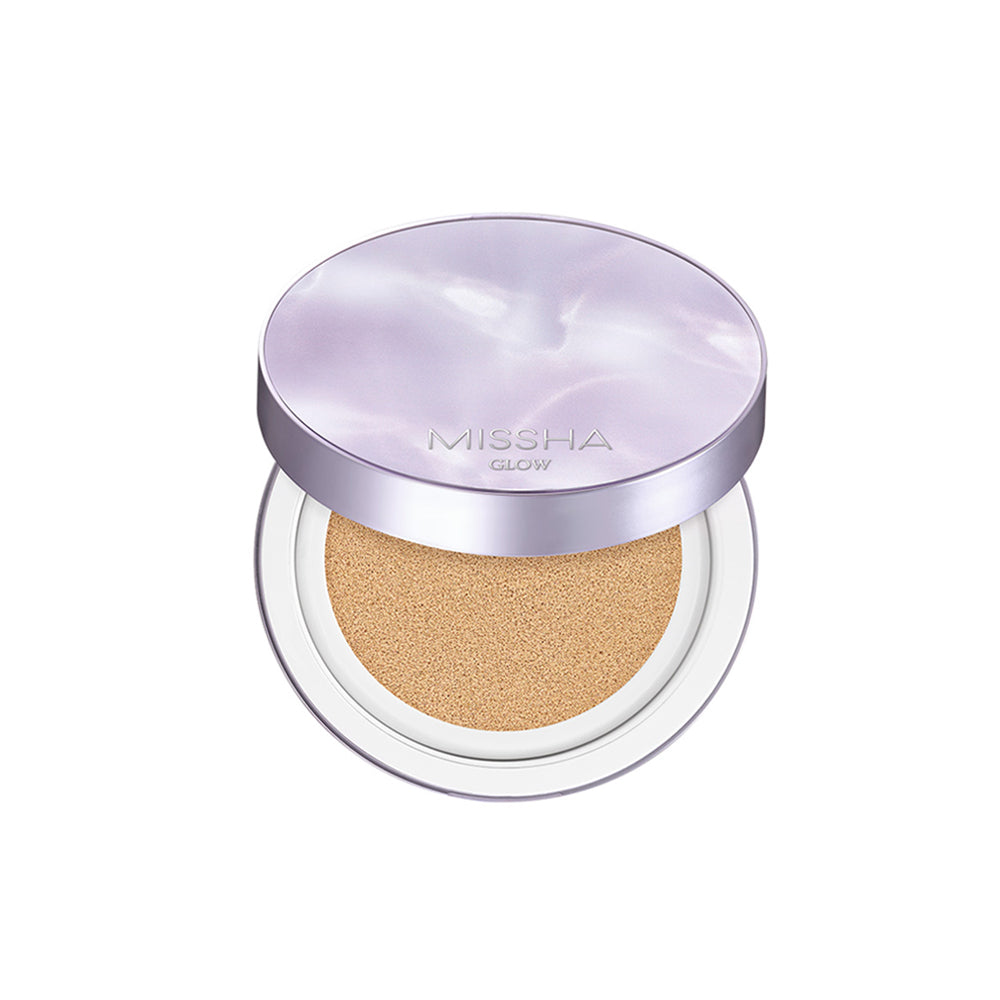 A compact Glow Layering Fit Cushion by Missha, with its lid open showing the BB cream inside. The cushion is pressed with a light-colored foundation, and the product is contained within a round, silver-colored case.