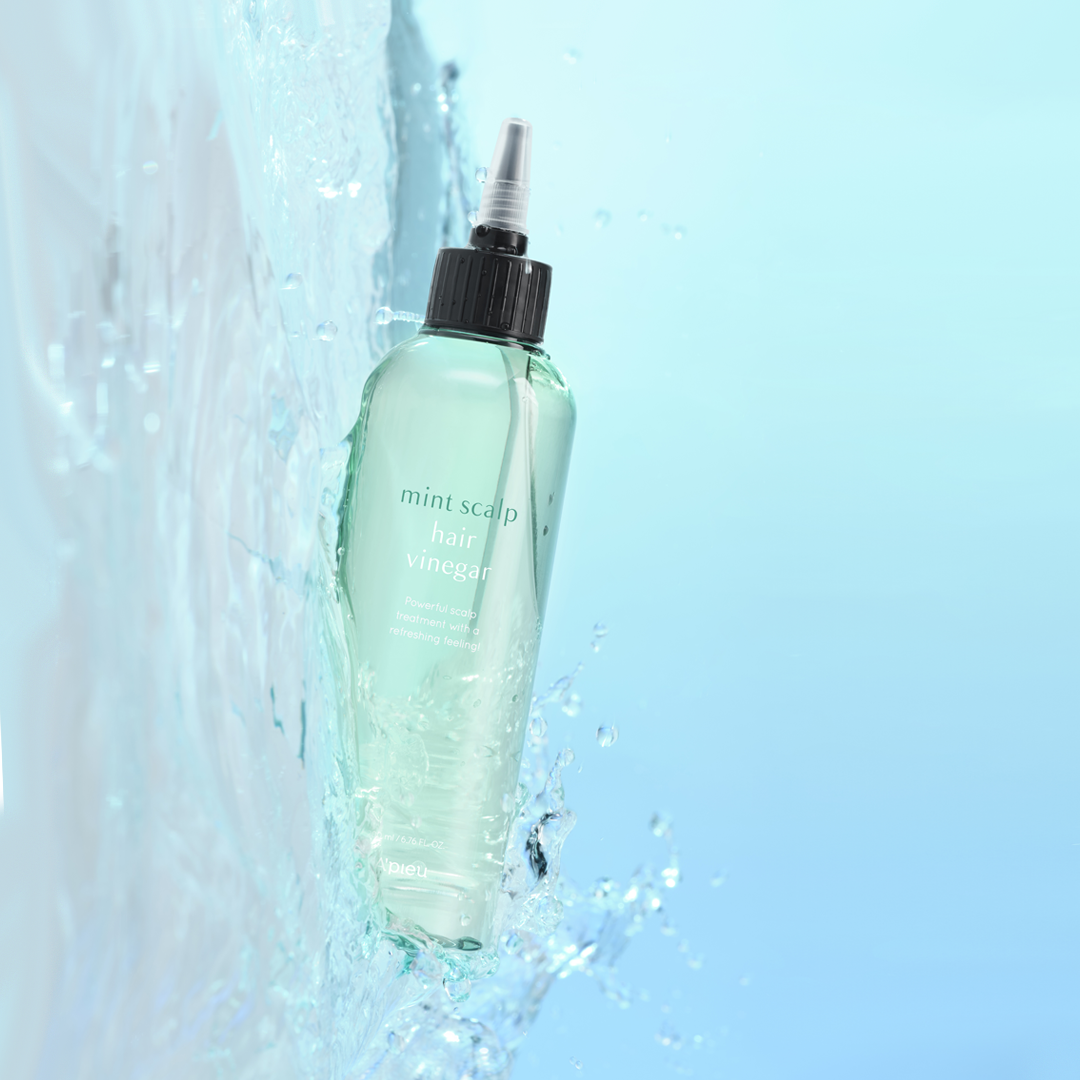 A’PIEU Mint Scalp Hair Vinegar bottle splashing in water, representing its cooling, refreshing scalp-cleansing formula and oil-balancing benefits