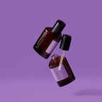 Two bottles of Missha Time Revolution Night Repair Ampoule 5X suspended in the air against a purple background, one with the dropper outstretched.