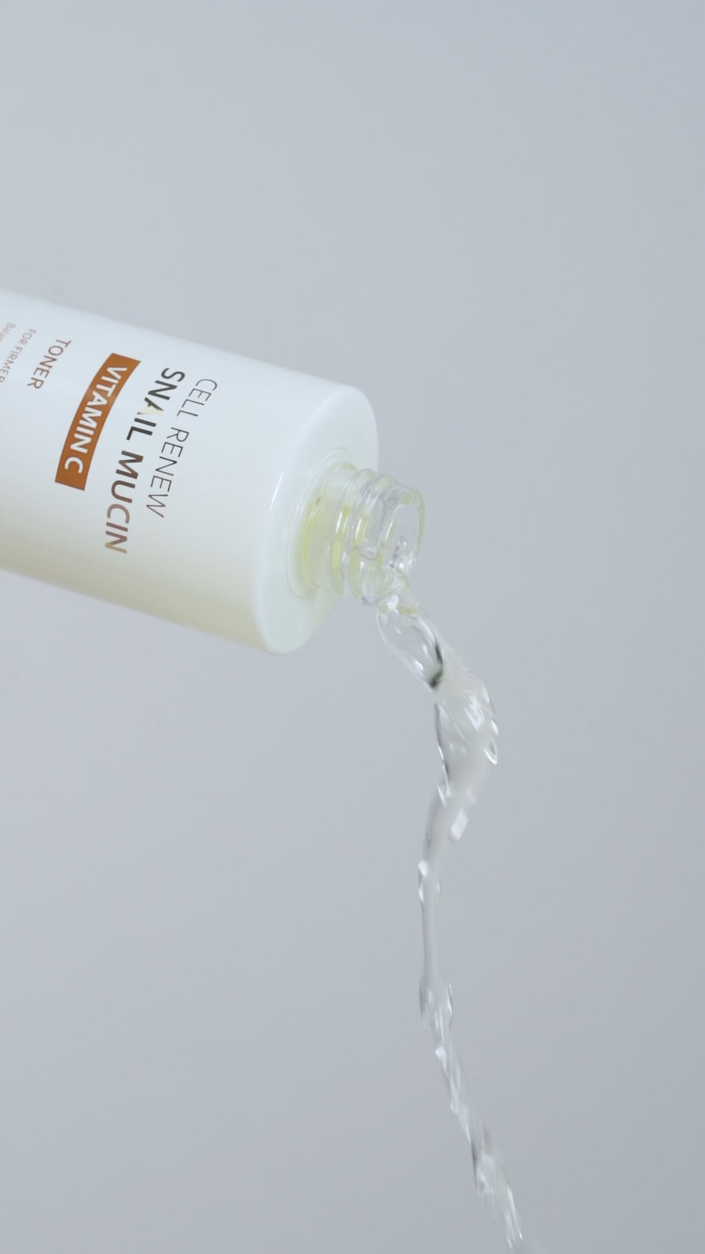 Extreme close-up of the Missha Cell Renew Snail Mucin Vitamin C Toner being poured out of the bottle, showcasing the clear, refreshing liquid texture of the K-Beauty skincare formula.