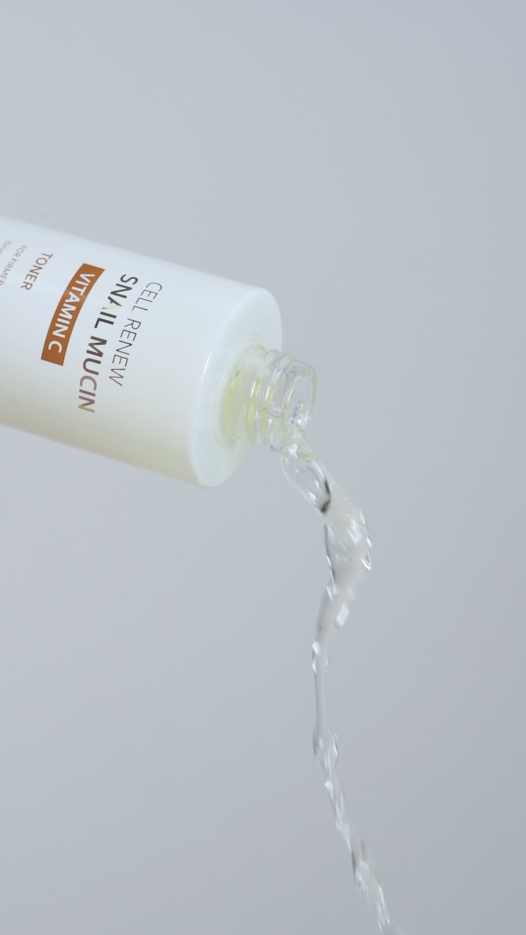 Extreme close-up of the Missha Cell Renew Snail Mucin Vitamin C Toner being poured out of the bottle, showcasing the clear, refreshing liquid texture of the K-Beauty skincare formula.