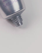 Close-up video showing the Missha Time Revolution Retinol 500IU Cream being gently squeezed from the tube, revealing a thick, white cream exiting the nozzle, demonstrating the controlled dispensing and rich texture of the anti-wrinkle Retinol cream