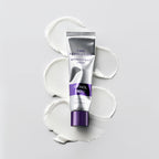 MISSHA Time Revolution Retinol 500 Shot Cream tube placed flat on a white surface with smooth cream swatches beneath it, showcasing its silky texture and elegant silver-purple packaging.