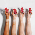 Four arms of different skin tones showing MISSHA M Perfect Cover BB Cream shade swatches, each holding a red tube of the product.