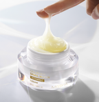 Extreme close-up of a finger lifting the Missha Cell Renew Snail Mucin Vitamin C Cream from the jar, demonstrating the thick, stringy, and highly viscous texture of the anti-aging moisturizing cream.