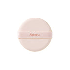 Close-up of the round, soft application puff for the A'pieu Cushion Foundation, featuring the 'A'pieu' logo on the light pink ribbon strap.