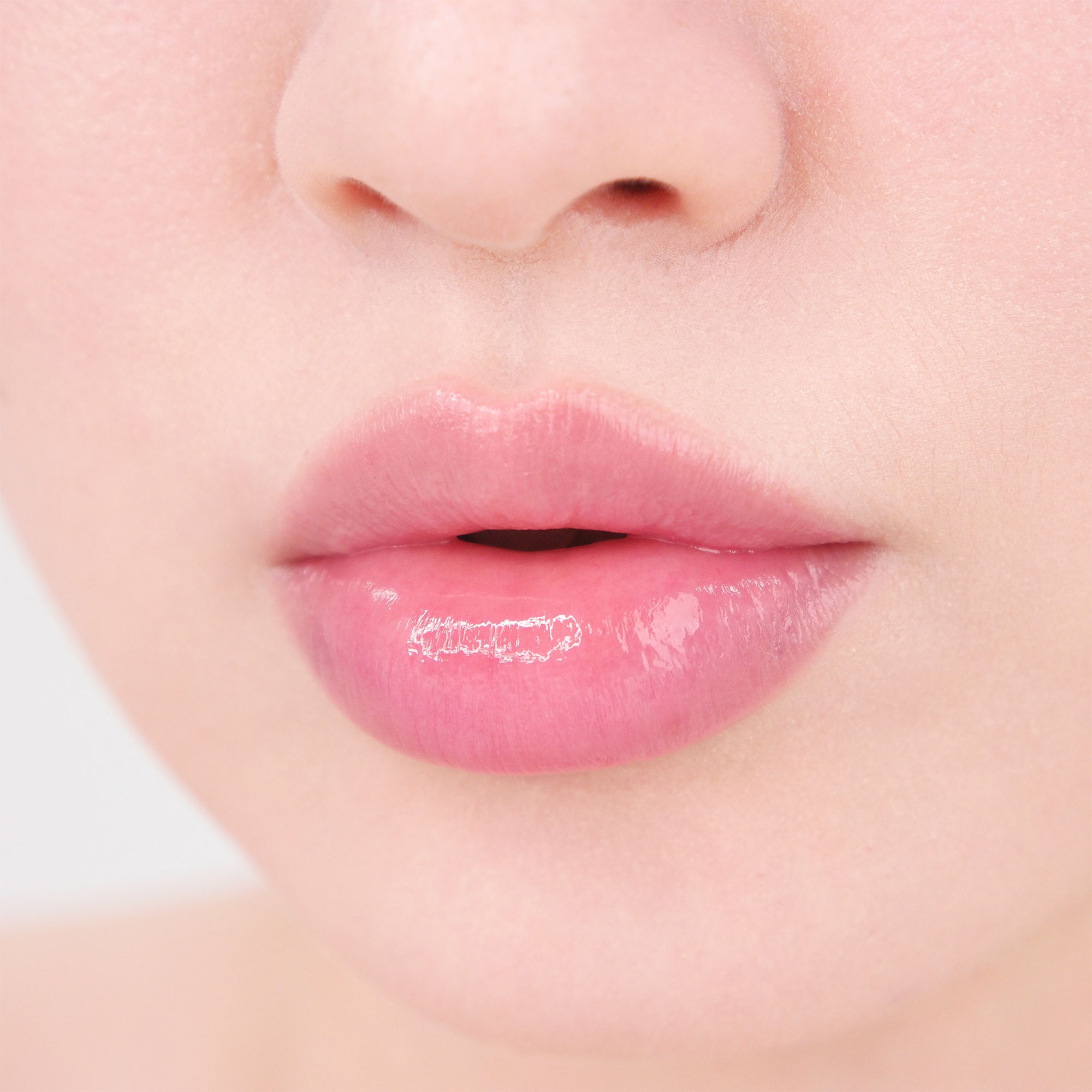 Close-up of glossy, hydrated lips with a natural pink finish, showcasing the smooth moisture effect of MISSHA lip care