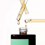 Close-up of multiple droppers dispensing the amber-colored liquid of the Missha Time Revolution Artemisia Calming Ampoule into the bottle opening. This visual emphasizes the potent, soothing serum texture for sensitive skin.