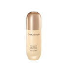 A bottle of Chogongjin Geumsul Jin Essence with a creamy beige liquid visible through a clear glass container with a gold-colored cap.