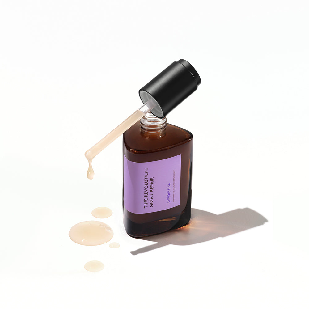 A dark amber bottle of the Missha Night Repair Ampoule 5X with the dropper cap removed, casting a shadow and featuring the light purple label. The milky serum is seen dripping onto the surface, highlighting the repair and anti-aging serum's consistency.