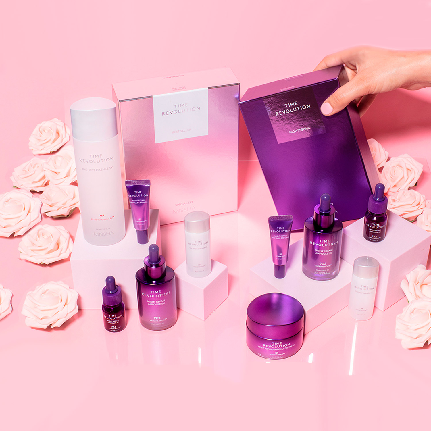 MISSHA Time Revolution skincare collection displayed on pink background with roses, featuring The First Essence, Night Repair Ampoule, Cream, and gift sets in signature purple and pearl packaging