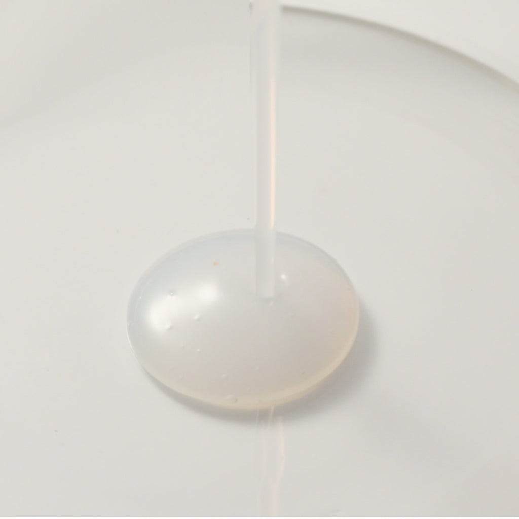 Chogongjin Geumsul Toner essence texture shot anti-aging K-Beauty product thick viscous liquid dispenses onto a white surface nourishing Hanbang formula.