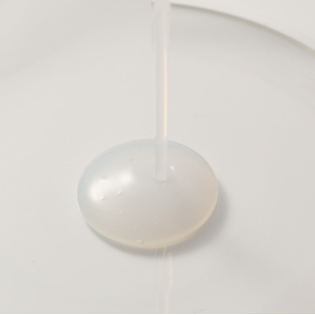 Chogongjin Geumsul Toner essence texture shot anti-aging K-Beauty product thick viscous liquid dispenses onto a white surface nourishing Hanbang formula.